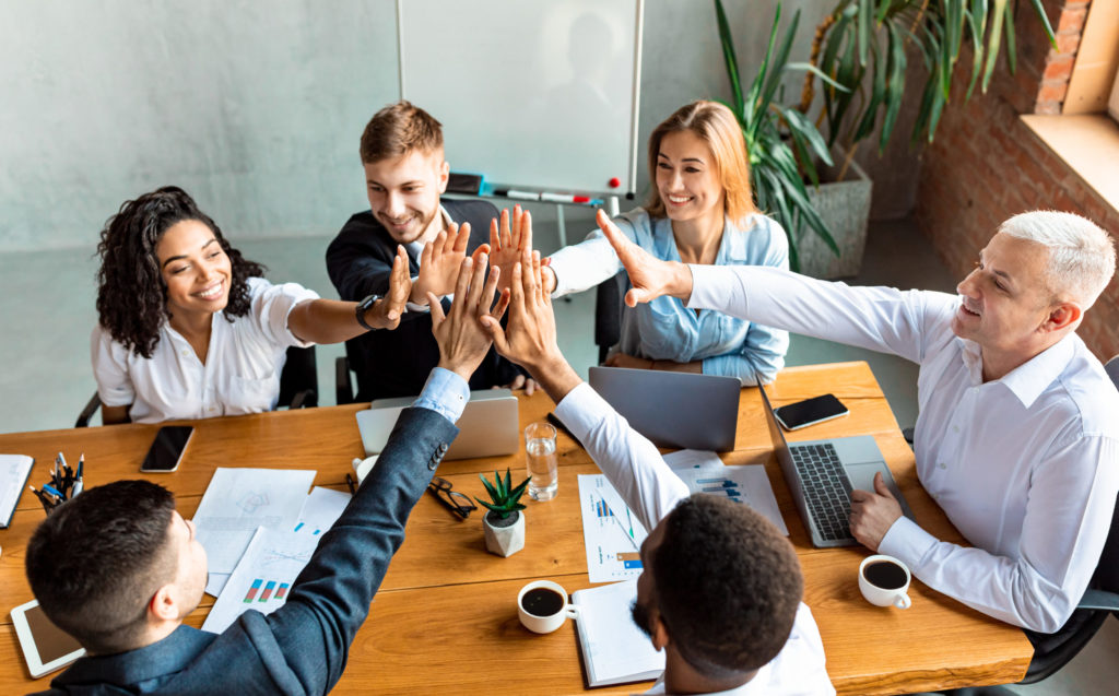 Happy Coworkers Giving High-Five Celebrating Business Success Sitting In Office